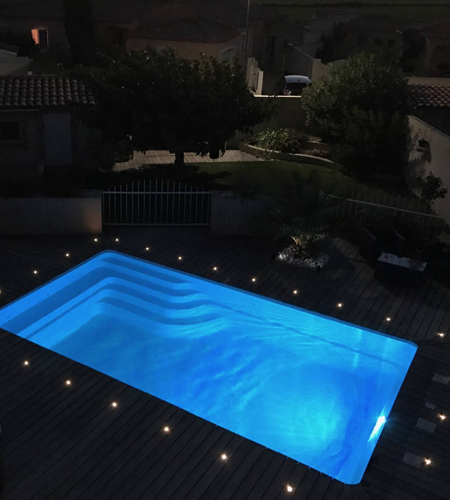 Piscine privée entourée de petits spots LED.